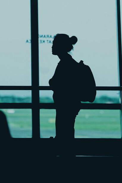 Surabaya, East Java, Indonesia, a silhouette of a woman with a backpack stands at an airport terminal