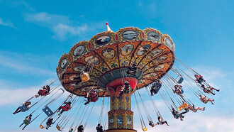 People enjoying a ride on a carousel at a theme park during the daytime