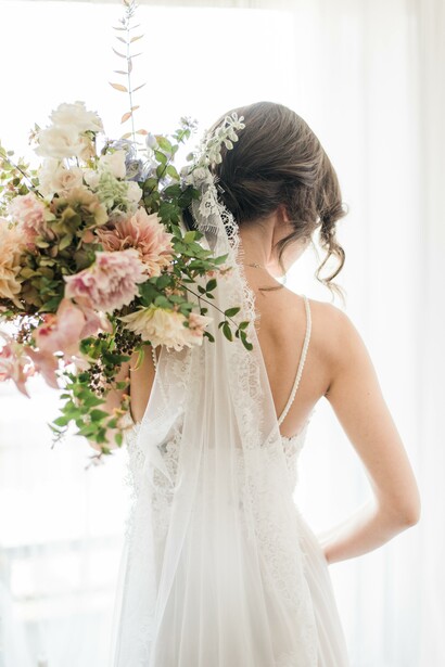 A woman in a white wedding dress holding a bouquet of flowers