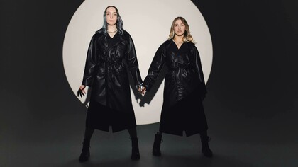 Modelle in trench di pelle nero su set fotografico