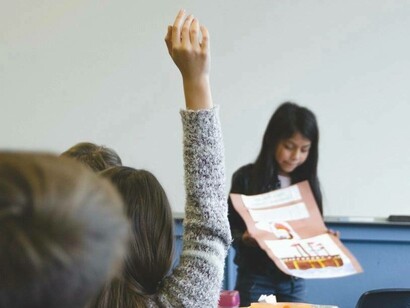 Bambini che ascoltano e intervengono durante una lezione in classe: è compito di chi dirige un Istituto scolastico formare ai valori etici e costituzionali