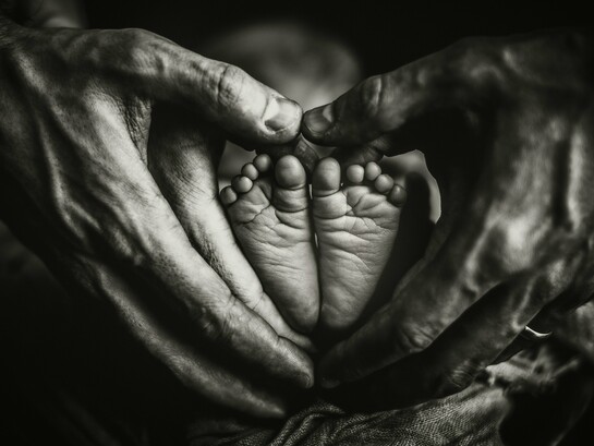 As mãos de dois adultos envolvem os pés de um bebê em formato de coração, simbolizando proteção, cuidado e a continuidade dos laços familiares. O artigo defende que a família deve permanecer como a principal fonte de orientação para as novas gerações. A transmissão de ensinamentos entre gerações é apontada como um dos pilares para a construção de lares duradouros. A transmissão de ensinamentos entre gerações é apontada como um dos pilares para a construção de lares duradouros