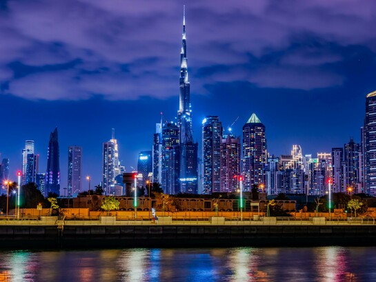 the Burj Khalifa in Dubai among dense urban towers at night, highlighting how engineering mastery supports vertical expansion