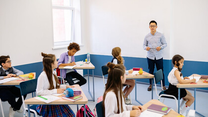 Insegnante spiega la lezione agli alunni mentre loro prendono gli appunti