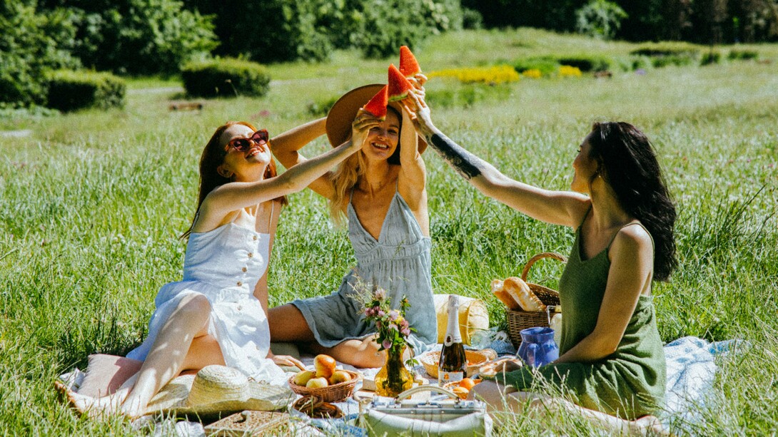 Friends sharing a picnic in the sunshine, representing the healing power of meaningful social connections