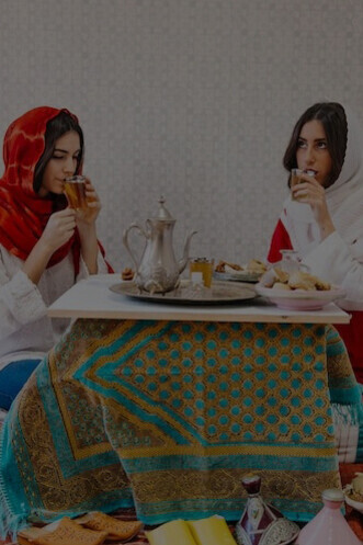 Iranian women indulging in tea and baklava, celebrating Iranian culinary traditions
