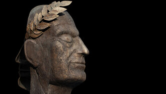 A bronze bust of Julius Caesar facing the dark