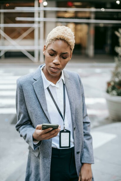 A woman looking at a mobile phone in the street
