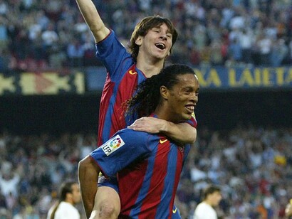 Lionel Messi celebrates with Ronaldinho after his first-ever Barcelona goal