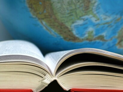 Un diccionario ante un mapa del mundo