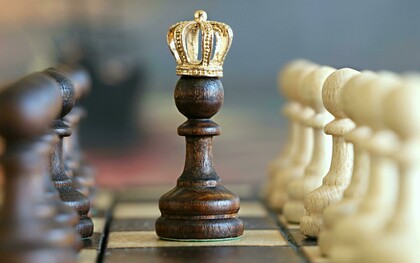 A chessboard with a pawn wearing a king’s crown, symbolizing growth, perseverance, and the journey to success