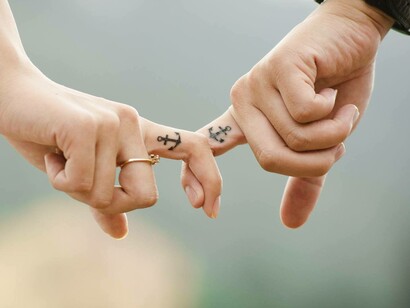 Una pareja pasaa cogida de los dedos