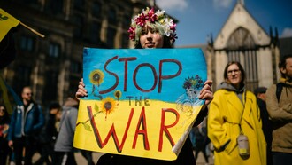 A fotografia de Michael Mücke mostra uma mulher com uma coroa de flores na cabeça, maquiagem que simula sangue no rosto e uma faixa com a mensagem “Stop the War” (“Parem a guerra”). A imagem combina a força visual do protesto com a expressão individual de quem transforma a indignação em manifestação pública. Embora a fotografia não tenha sido feita na Ucrânia, ela dialoga com a dimensão internacional do conflito e com a necessidade de colocar a proteção da vida acima dos interesses militares e geopolíticos