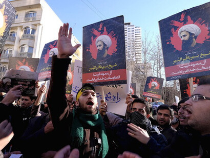 Iranian protesters chant slogans as they hold pictures of Shiite cleric Sheikh Nimr al-Nimr during a demonstration against his execution