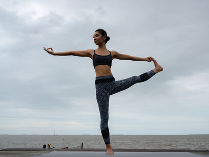Giovane donna che esegue Utthita Hasta Padangusthasana (posizione estesa con mano all'alluce). Ci sono studi condotti da neuroscienziati di tutto il mondo che hanno dimostrato che alcune pratiche yoga possono aiutare nel combattere gli stati di ansia