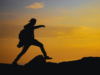 A lone adventurer crossing a divide with confidence, reflecting the power of decisive action