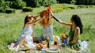 Friends sharing a picnic in the sunshine, representing the healing power of meaningful social connections