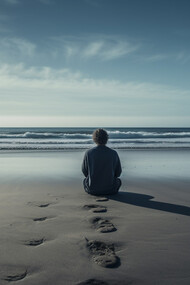 A solitary figure sitting by the vast sea, representing the quiet ache of emotional isolation