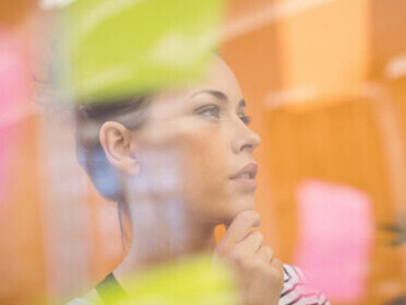Female executive strategizing and setting goals while reviewing sticky notes