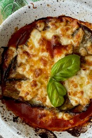 La parmigiana di melanzane nasce nel Sud Italia come piatto estivo di stratificazione, probabilmente tra Settecento e Ottocento, con origini contese e un nome ancora oggi discusso tra “parmiciana” siciliana e Parmigiano