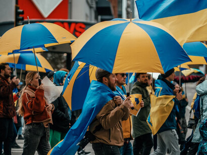 People holding umbrellas as they walk through the streets of Seattle USA, participating in an anti-war protest in solidarity with Ukraine