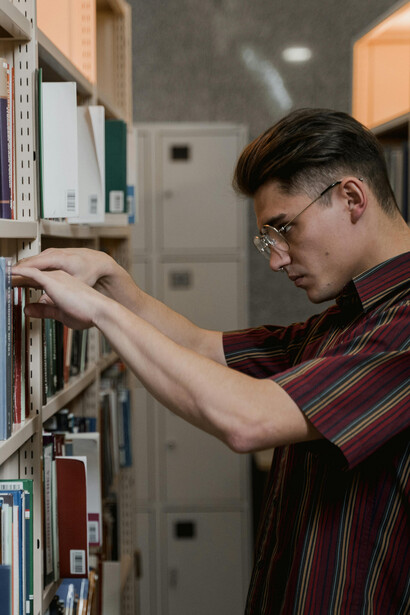ALuno procura livro na biblioteca de uma universidade