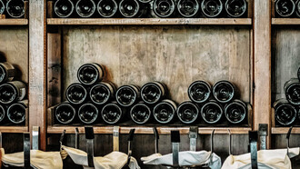 The sophisticated allure of black wine bottles elegantly displayed on a rustic wooden shelf, adding a touch of timeless charm to your wine collection