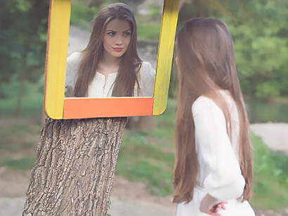 A symbolic portrayal of a young woman gazing into a forest mirror, evoking themes of self-reflection and narcissism within natural surroundings