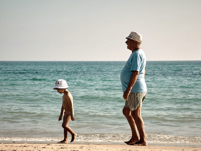 Niños y su abuelo caminando por la playa