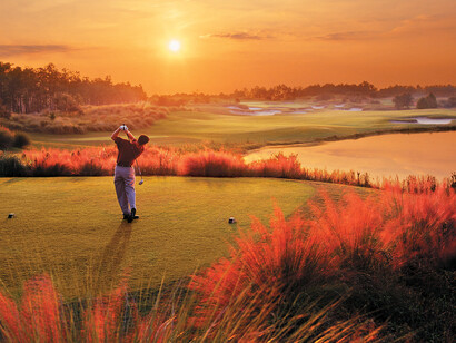Golfista jugando unos hoyos al atardecer