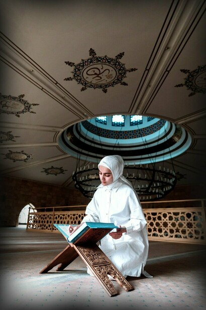 Muslim woman reading Quran in mosque