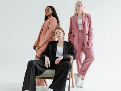 Women wearing business coats against a white background
