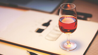 A glass of rich red wine sits elegantly on the table, adding a touch of sophistication to the scene