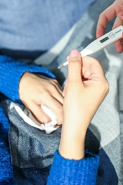 Woman receives thermometer to check for a fever