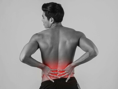 A man suffering from lower back pain caused by poor posture, inactivity, or stress
