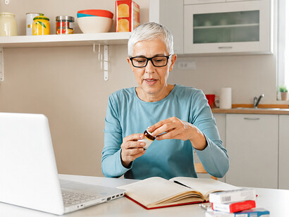 A woman reviews medical information and prescription details on her computer