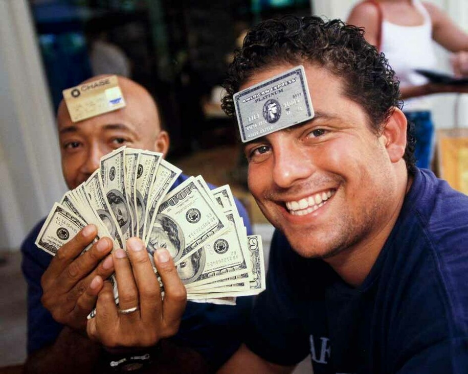 Film director and producer Brett Ratner (right), 29, and Russell Simmons, 41, a businessman and cofounder of hip-hop label Def Jam, at L’Iguane restaurant, St. Barts, 1998. Few establishments on the island accepted credit cards, and visitors often carried large amounts of cash. © Lauren Greenfield
