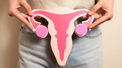 Front view woman holding woman reproductive system cardboard