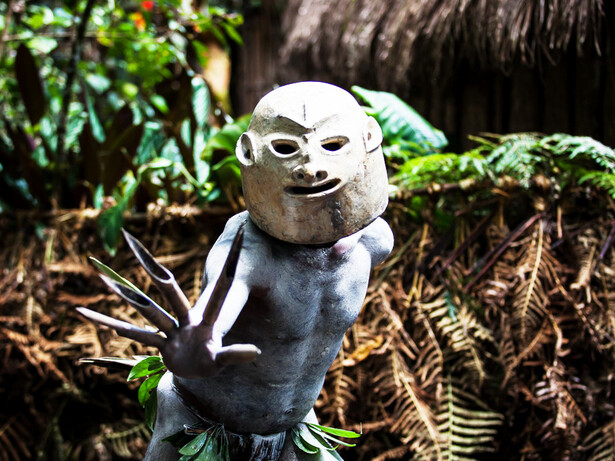 Northeast of the city Mount Hagen, Papua New Guinea, in the rural Paiya Village, an Asaro mudman dons his ancestral clay mask, embodying the fierce spirit of a tribal warrior