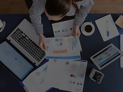 Top view of businesswoman sitting at desk table checking financial accounting documents