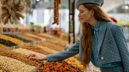 A woman buying seeds and nuts at the market for a healthy lifestyle