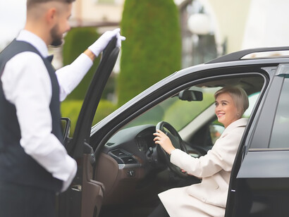 Experience luxury as a parking valet assists a VIP client in parking her car, offering high-end services tailored for exclusive events