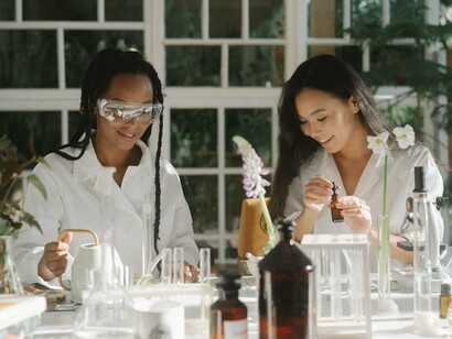 Scientists collaborating around laboratory equipment and plant specimens, symbolizing the search for new knowledge