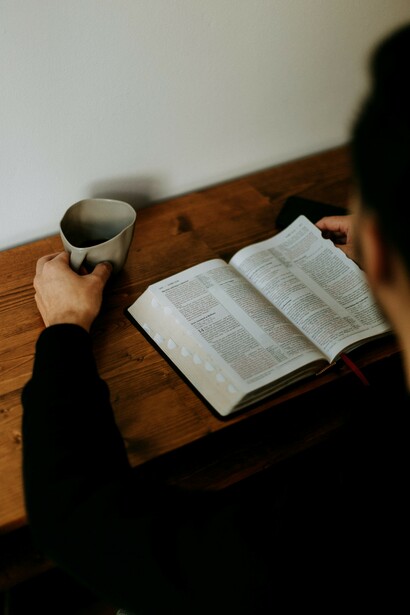 A man reading the Bible in church, reflecting on scripture as part of his spiritual struggle and journey toward redemption