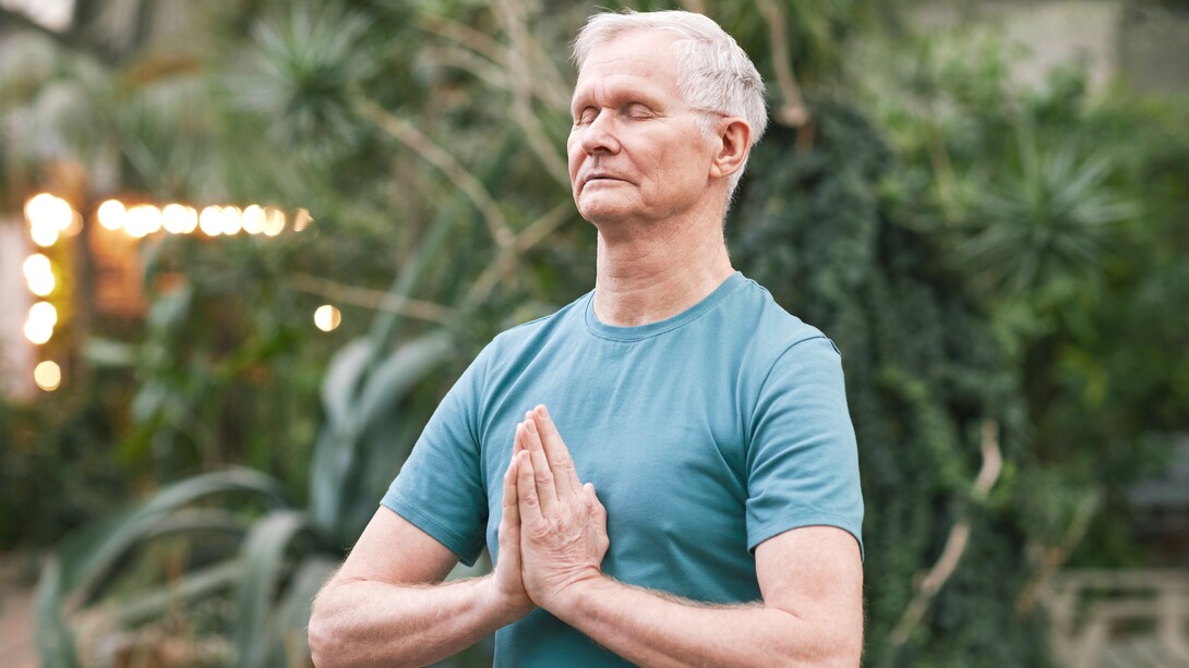 Homem idoso pratica meditação