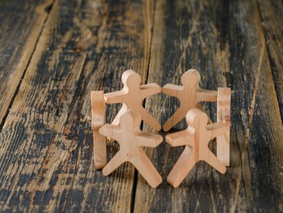 Wooden figures of people holding hands symbolize the unity and collective strength of human rights activism, civil society organizations, and the ongoing fight for social justice