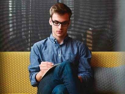 Un joven escribe en un papel