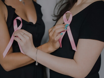In a compelling visual representation, two women elegantly holding pink ribbons exemplify a strong commitment to cancer awareness and holistic health, contributing to a collective effort for improved well-being