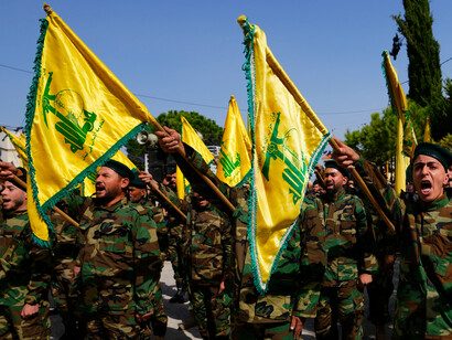 Combatentes do Hezbollah aparecem armados e uniformizados durante uma mobilização do movimento no Líbano. O grupo constitui uma das principais forças ligadas ao “Eixo de Resistência” e mantém uma frente de confronto com Israel a partir do território libanês