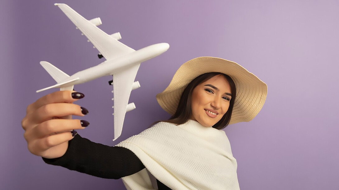 A woman with white scarf in summer hat showing toy airplan